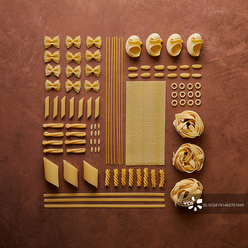 各种干意大利面在铜背景上的食品摆拍图片素材