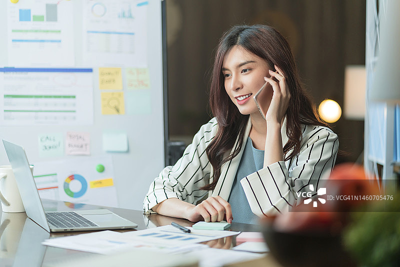 在客厅公寓通过手机在线会议应用程序与商业伙伴进行视频会议的亚洲女性图片素材