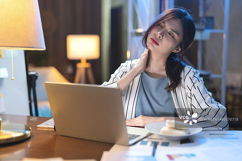 感到有压力的年轻亚洲自由职业女商人深夜在家工作，头痛的女企业家图片素材