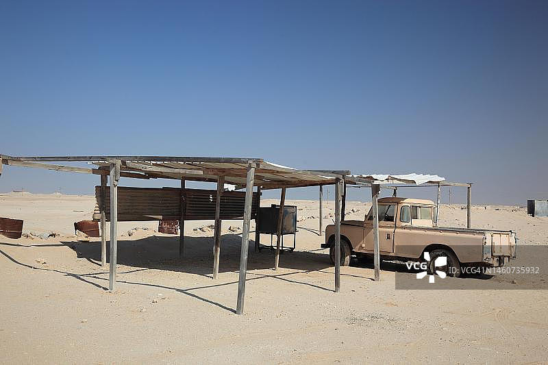 卡塔尔沙漠中的停车场和旧皮卡图片素材