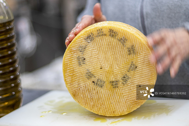 工作中的女性正在涂抹橄榄油奶酪图片素材