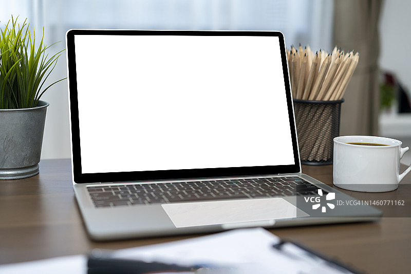 在家中桌子上放着热咖啡的笔记本电脑图片素材
