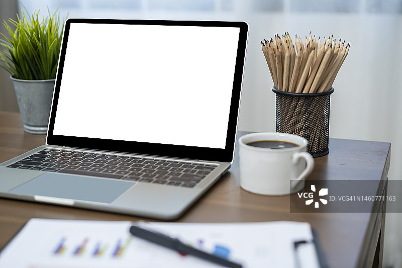 在家中桌子上放着热咖啡的笔记本电脑图片素材