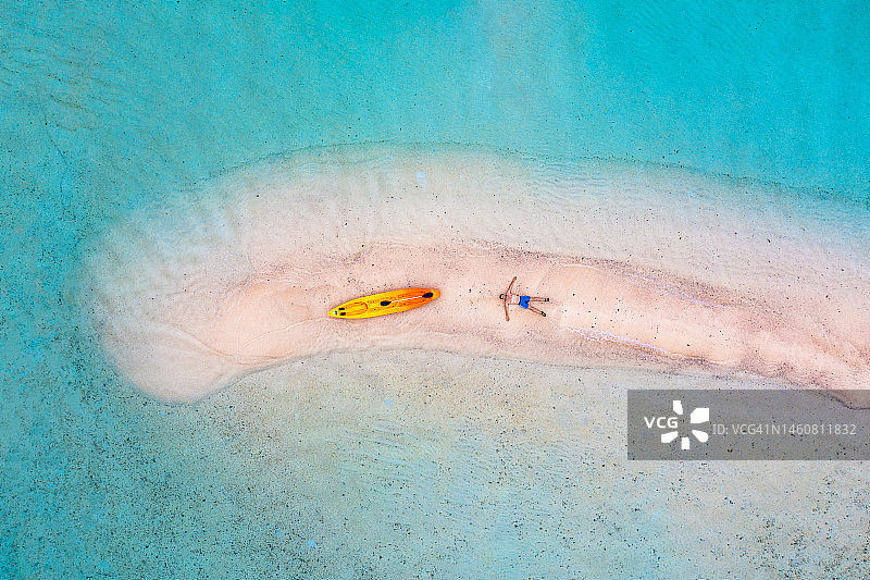在菲律宾沙洲上划着皮划艇放松的男人（鸟瞰图）图片素材