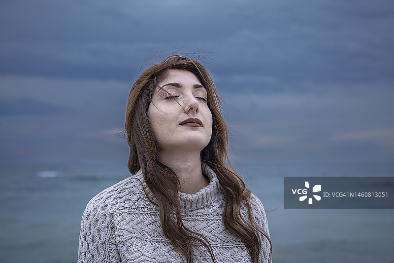在海边大风天气中拥有一双蓝色眼睛的美丽女人图片素材