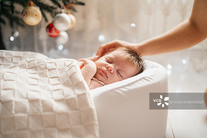 母亲轻抚熟睡的新生女儿图片素材
