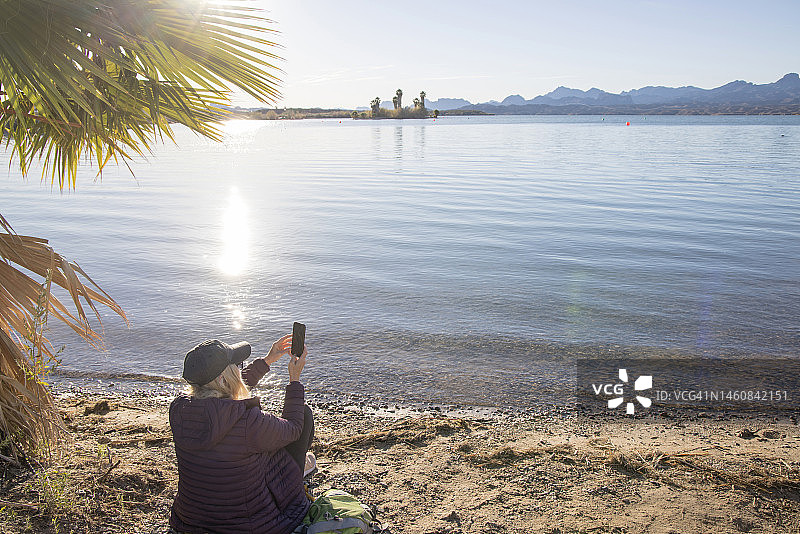 中年妇女拍摄湖面照片图片素材