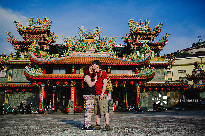游客夫妇在台湾九份市的彩色寺庙前拥抱图片素材