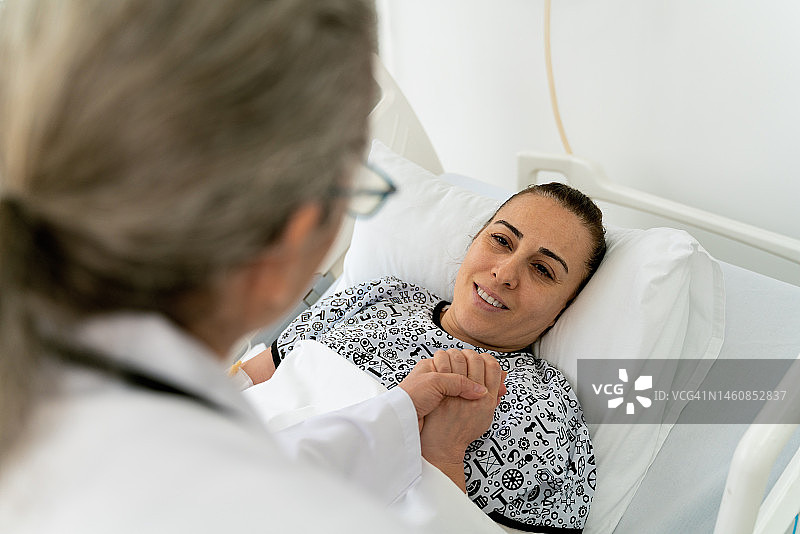 年长的女医生检查住院的年轻女病人图片素材
