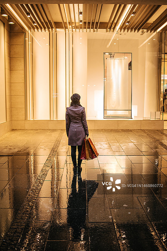 女人看着精品店的橱窗图片素材