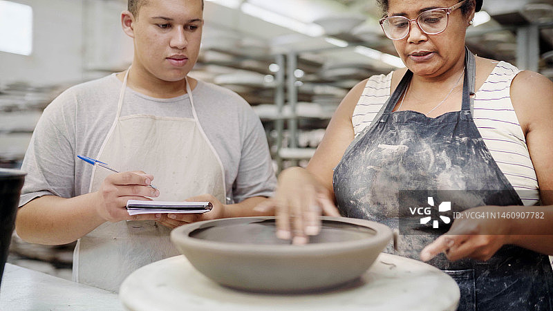 女教师在陶瓷厂教同事如何制作碗图片素材