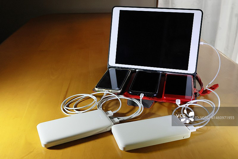 通过移动电源为平板电脑和智能手机充电图片素材