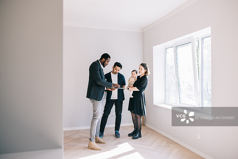 年轻家庭与房地产经纪人签订合同图片素材