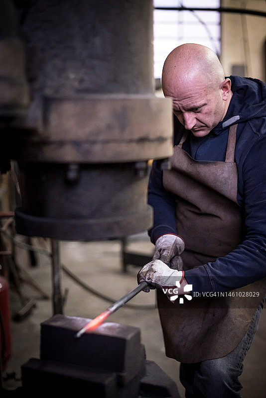 铁匠艺术家在他的铁匠工作室里制作门树图片素材