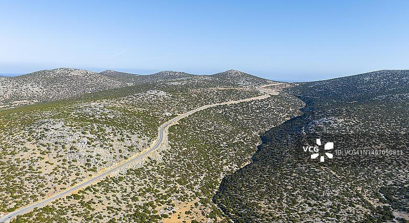 希腊阿斯提帕莱亚干燥景观中的孤独公路图片素材