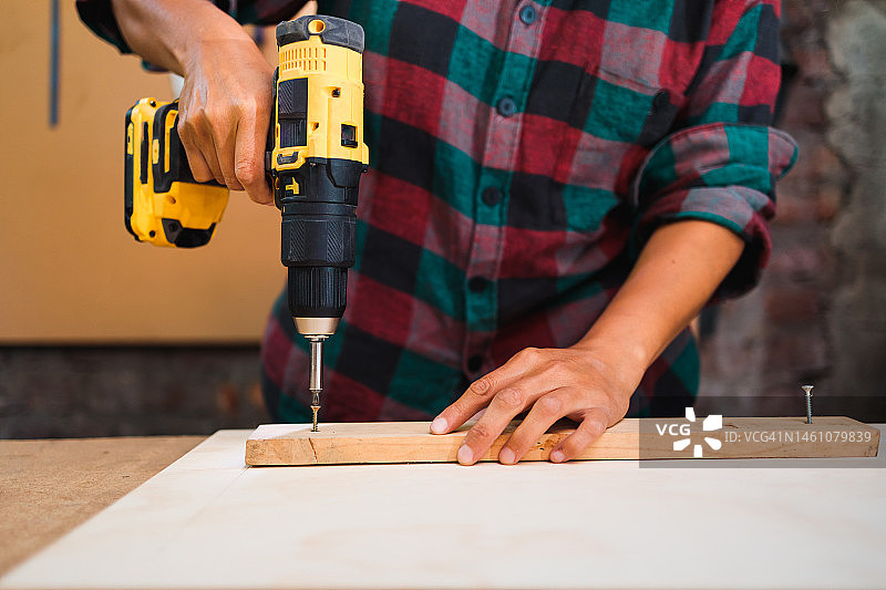 拉丁裔女木工在家用电钻钻木板（未识别）图片素材