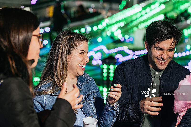 朋友们在城市集市上边吃边喝，开怀大笑图片素材