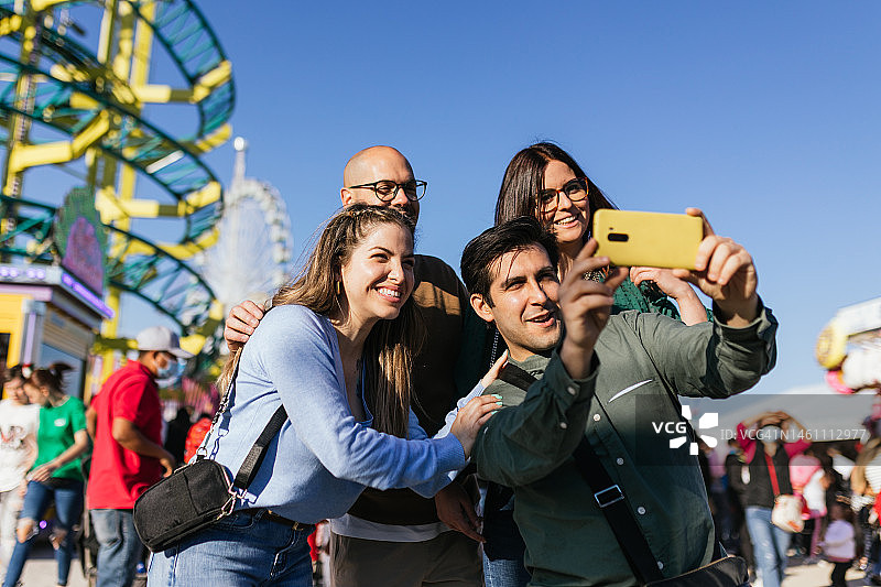 朋友们在集市上用手机录像，玩得很开心图片素材