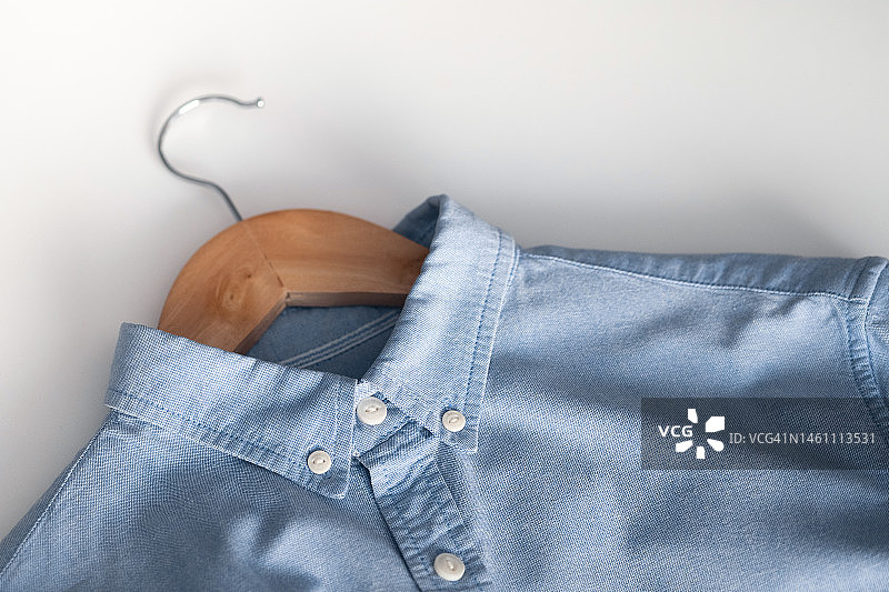 纯中性棉质衬衫，服装店货架上悬挂的衣服图片素材