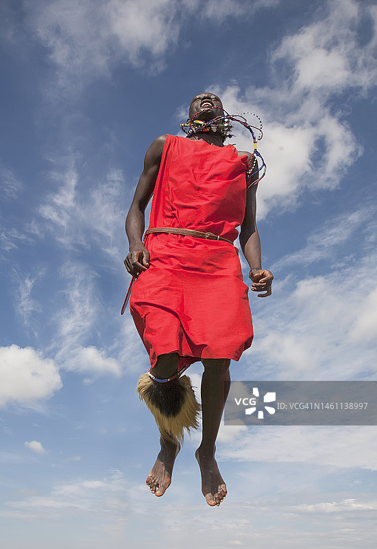 马赛族男子在传统舞蹈中跳跃图片素材