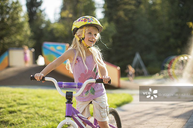 年轻女孩和妈妈在公园骑自行车图片素材