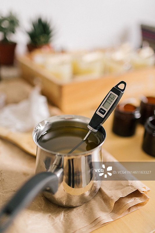 融化的豆蜡中的温度计图片素材