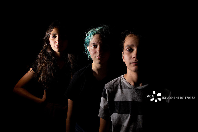 戏剧光线下三兄妹的肖像图片素材