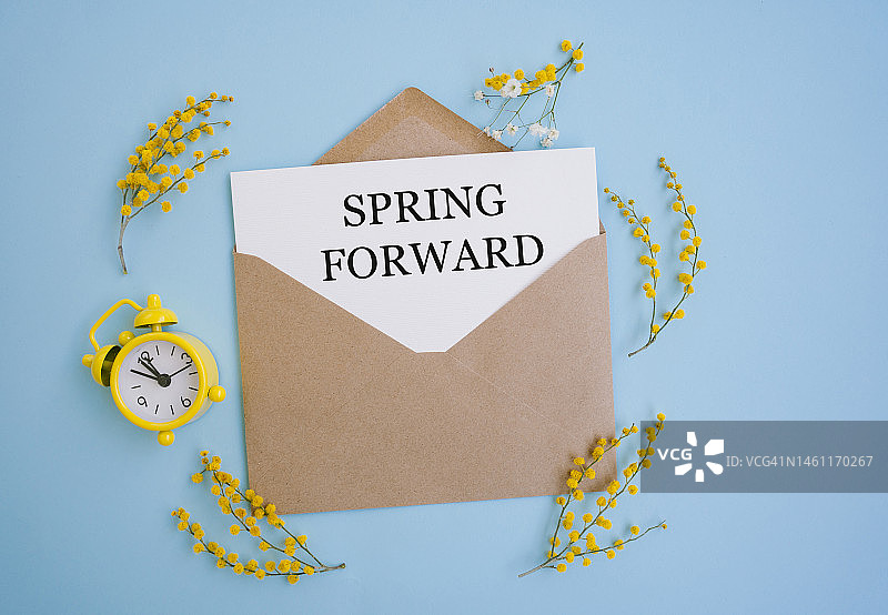 纸卡上的春季向前文本、信封、闹钟和春季黄色花卉图片素材