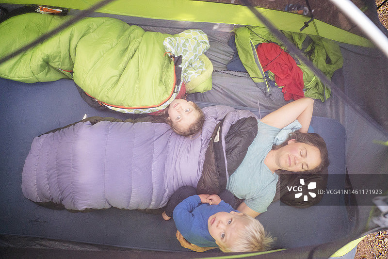 妈妈和两个孩子在帐篷里的睡袋中图片素材