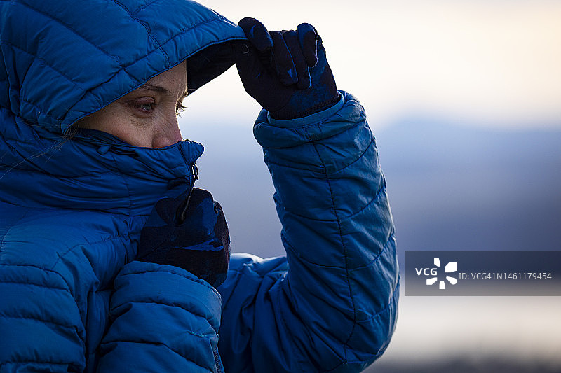 身穿蓝色羽绒服的女子抱团取暖图片素材