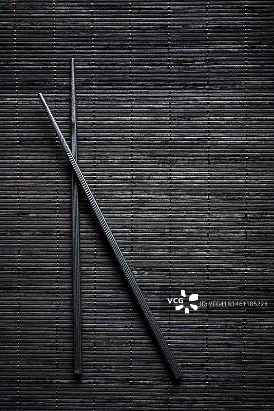 黑色蔬菜桌布上的一双筷子图片素材