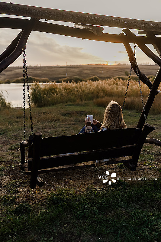 女孩欣赏湖边美丽日落图片素材