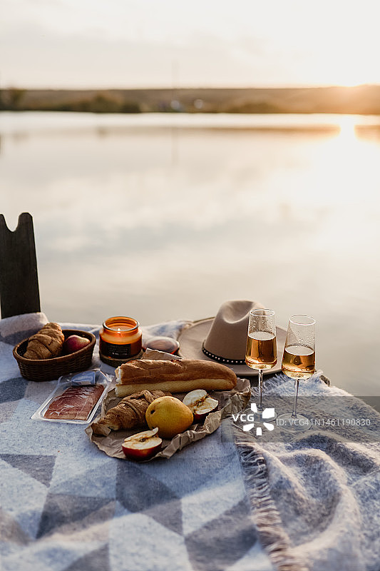 户外精美野餐，包含葡萄酒杯、面包和浆果图片素材