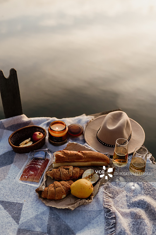 户外精美野餐，包含葡萄酒杯、面包和浆果图片素材