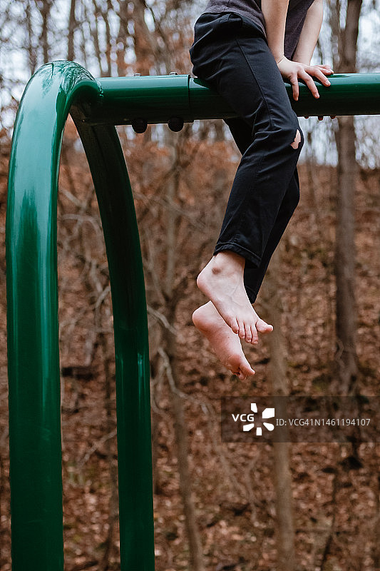 儿童在游乐场上攀爬，双脚悬空图片素材