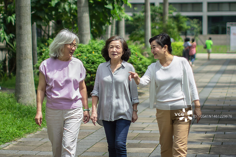 在宁静公园中漫步的喜悦老年妇女图片素材