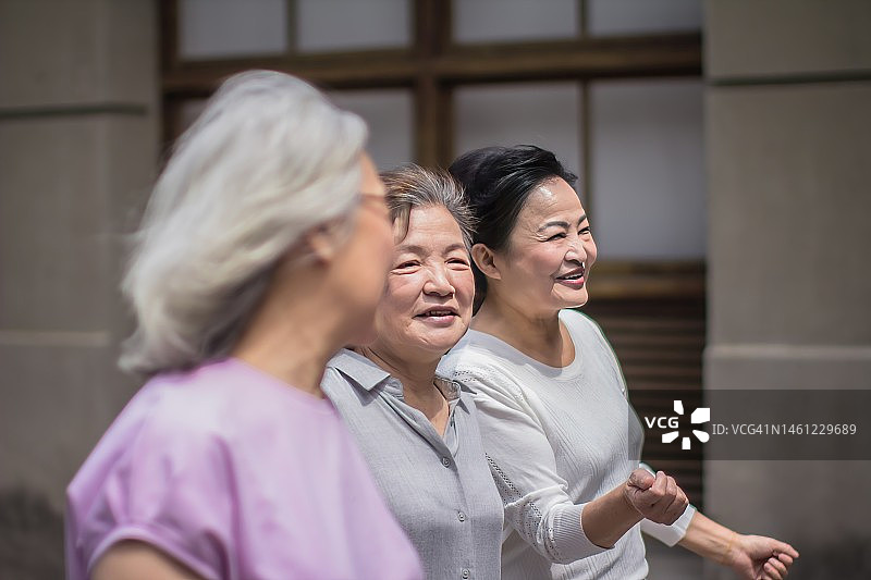 快乐的中年妇女在悠闲漫步时交谈图片素材