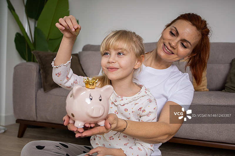 快乐的一家人往储蓄罐里投钱图片素材