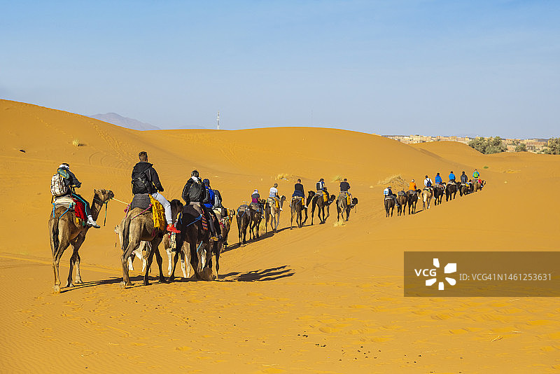 游客在摩洛哥撒哈拉沙漠Erg Chebbi的梅尔祖卡骑骆驼图片素材