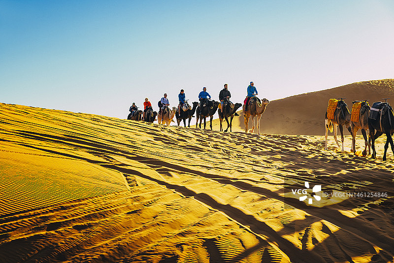 游客在摩洛哥撒哈拉沙漠Erg Chebbi的梅尔祖卡骑骆驼图片素材