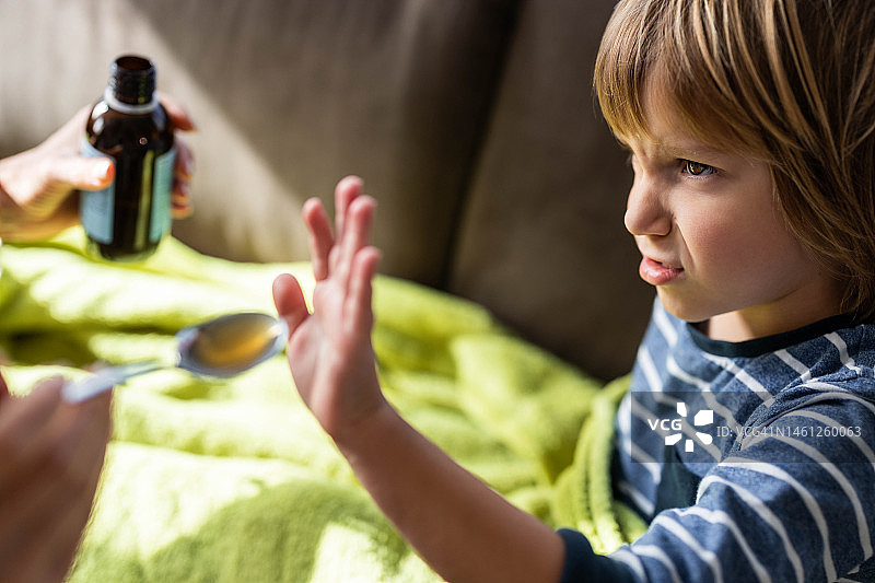 生气的小男孩在家拒绝喝药图片素材