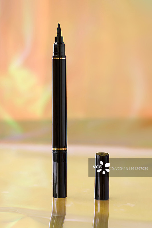 黑色眼线在彩色背景上的特写，化妆品与美容行业概念图片素材