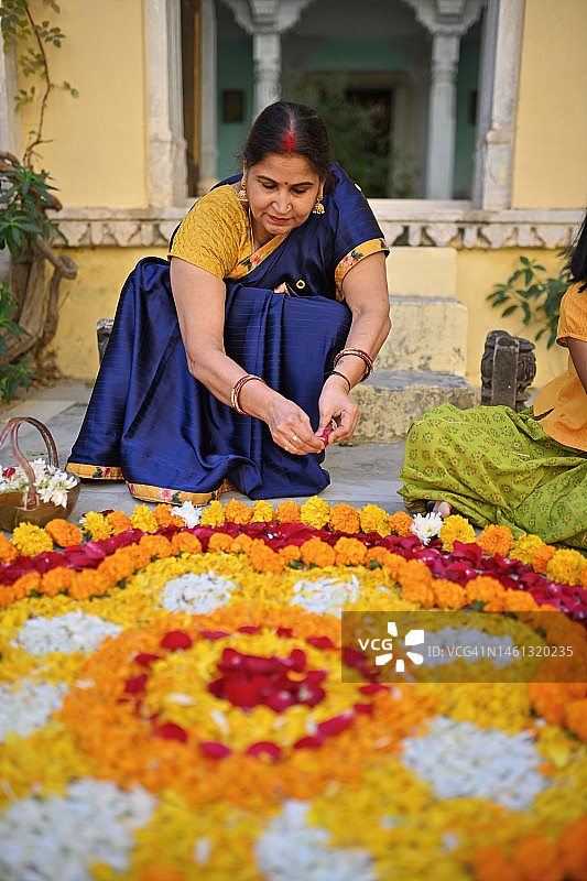 用万寿菊花制作蓝果丽图案的老年妇女图片素材