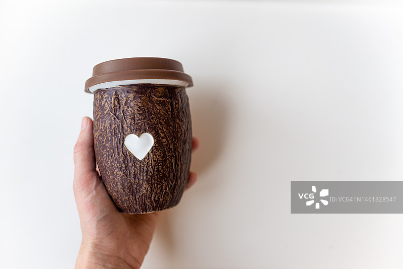 女孩手拿可重复使用的玻璃咖啡杯和外卖热饮。零浪费、自觉消费和环保概念图片素材