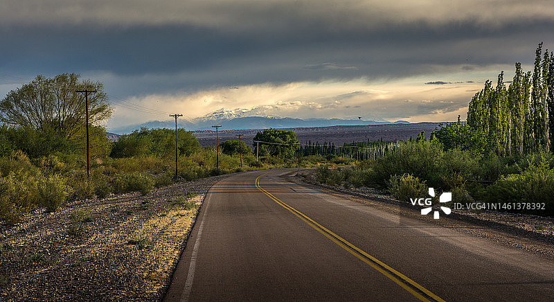 阿根廷圣胡安卡林加斯塔的树木和天空之间的空旷道路图片素材