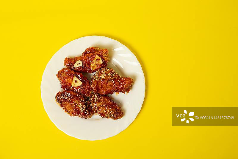 黄色背景下，盘中炸鸡翅俯视图，印度尼西亚图片素材