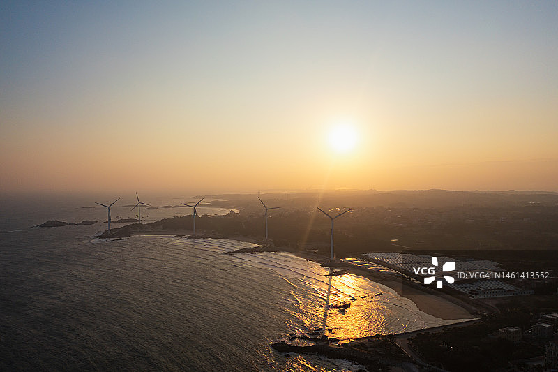 日落时分的海边风力发电场图片素材