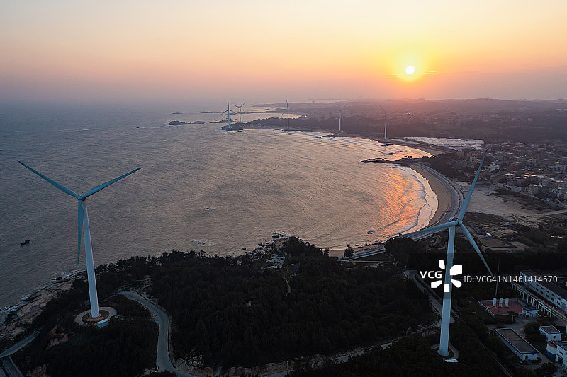 日落时分的海边风力发电场图片素材