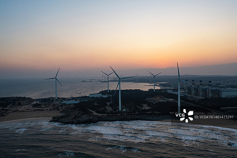 日落时分的海边风力发电场图片素材