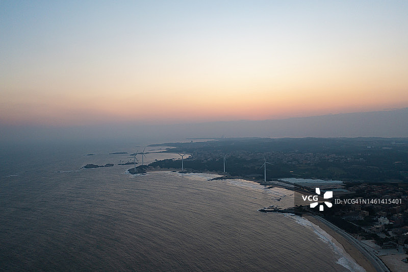 日落时分的海边风力发电场图片素材